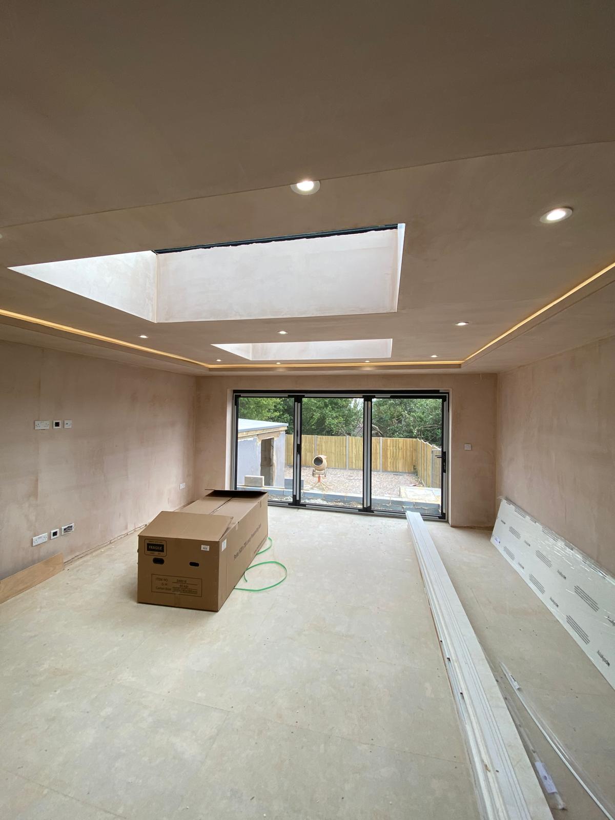 Extension shell plastered out with roof lanterns and bifold opening