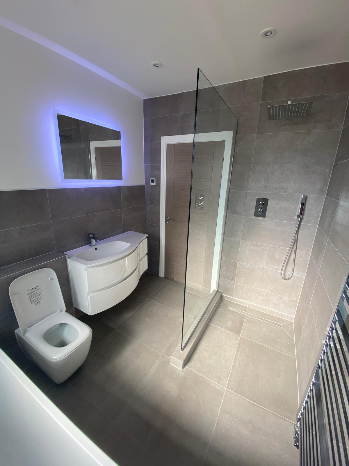 Renovated bathroom with walk-in shower and tiled walls