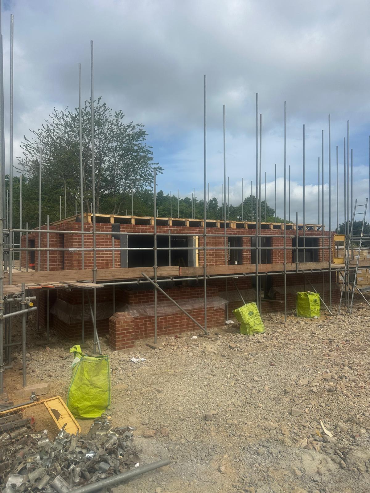 Single-storey new build at wall-plate height, scaffolded