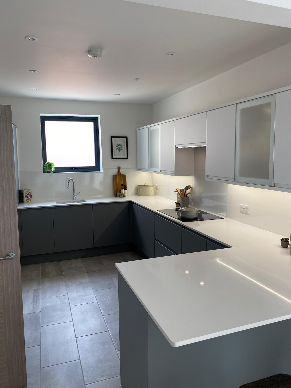 New handleless grey kitchen with quartz worktops in a finished extension