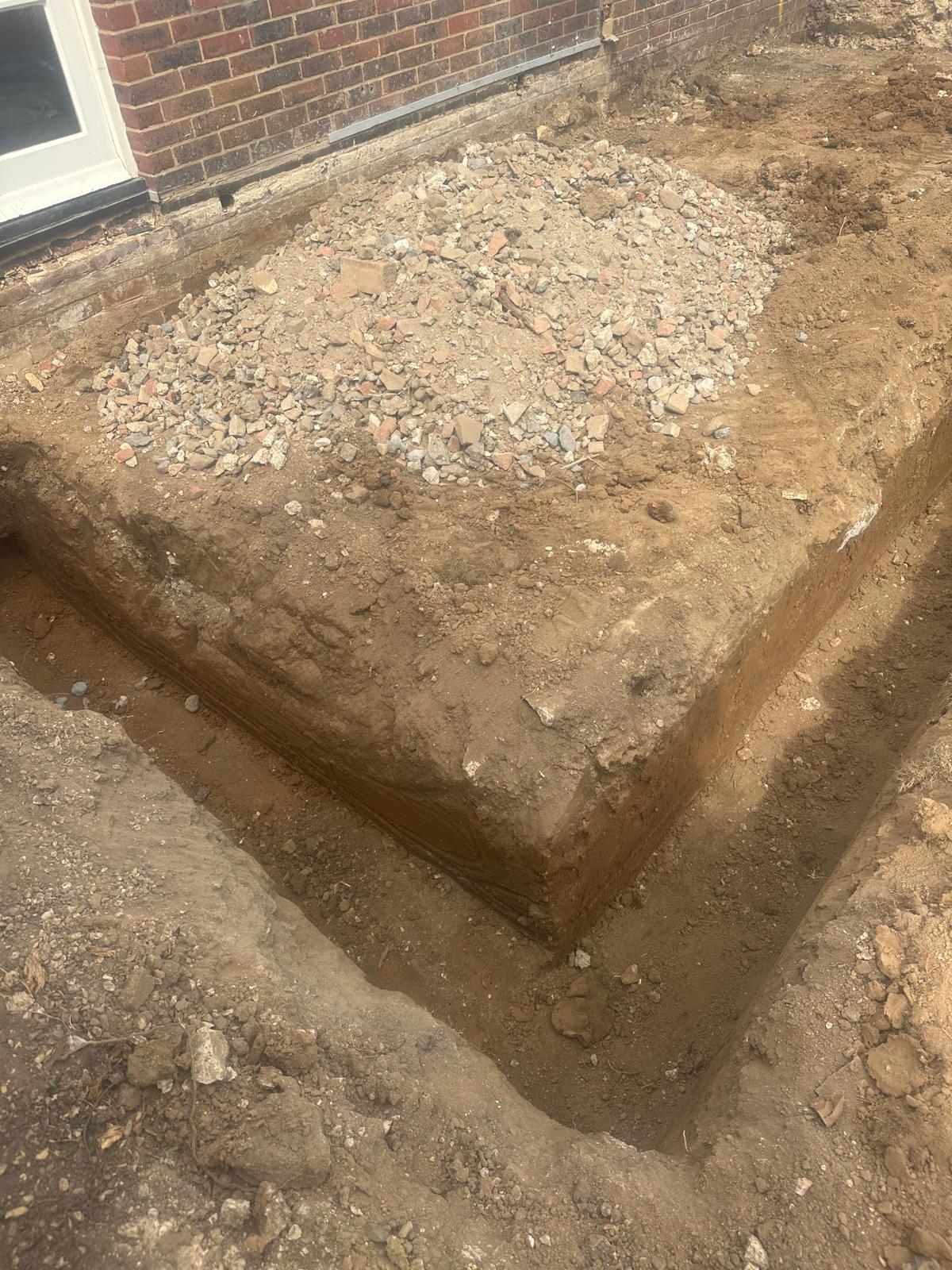 Hand-dug strip foundation with hardcore fill