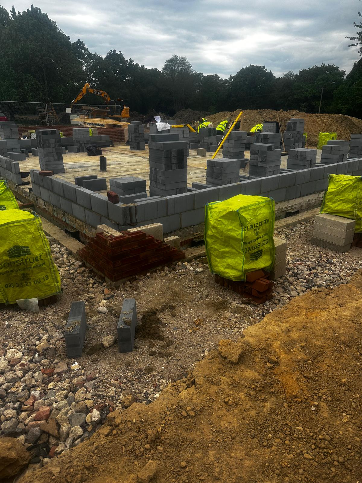 Early-stage blockwork with plant on site